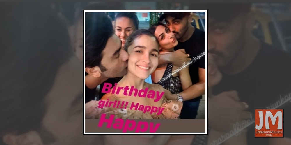 A picture of actor Ranbir Kapoor giving a sweet kiss to actress Alia Bhatt, who just turned 27, has gone viral on social media. In the photo, Ranbir can be seen giving a peck on Alia's cheek. In the background, Arjun Kapoor can be seen holding Malaika cl