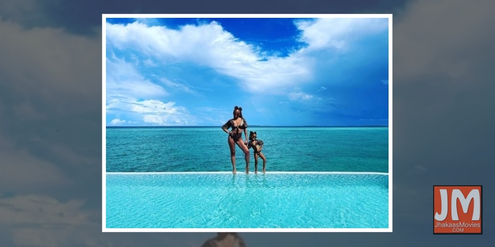 Chrissy Teigen, daughter Luna twin in black bikinis.