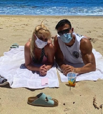 Britney Spears goes on beach date in mask and bikini.