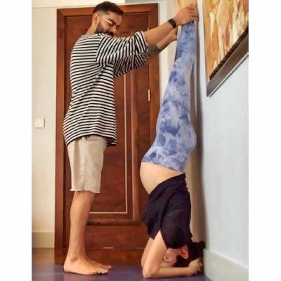 Pregnant Anushka Sharma performs Shirshasana with Virat's support.